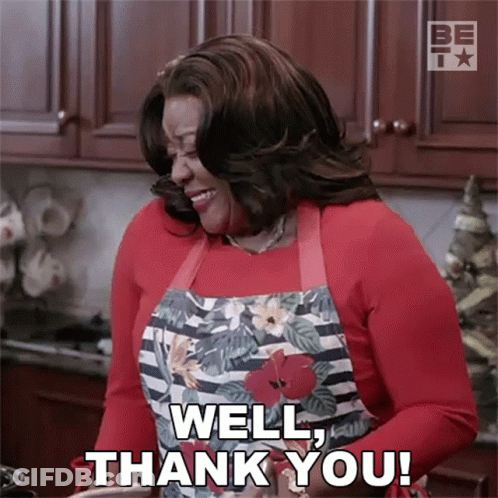 A Woman Wearing An Apron Is Saying Well Thank You GIF