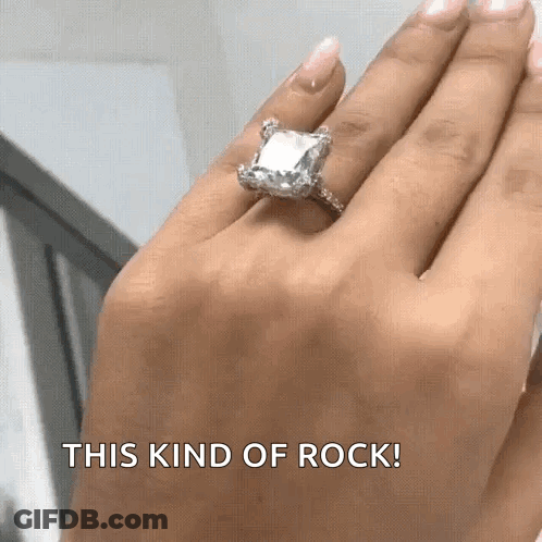 A Woman Wearing An Emerald Cut Diamond Ring On Her Left Hand GIF
