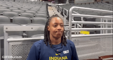 A Woman Wearing An Indiana Shirt Stands In An Empty Auditorium GIF