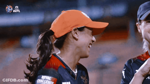 A Woman Wearing An Orange Hat With The Word Royal On It GIF