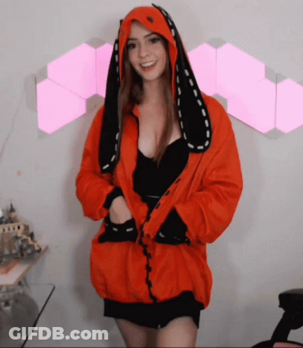 A Woman Wearing An Orange Jacket With Bunny Ears On Her Hood GIF