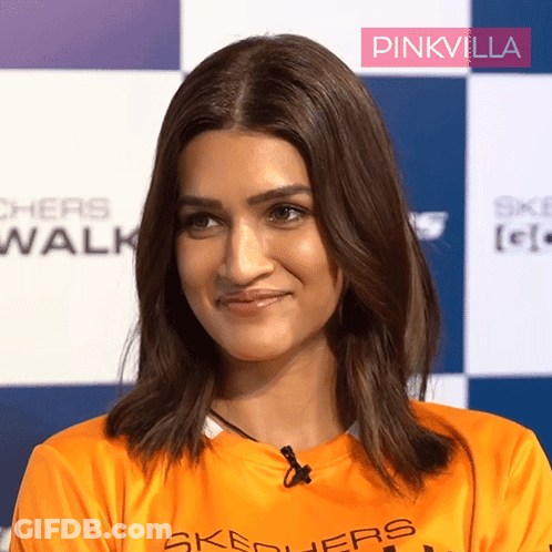 A Woman Wearing An Orange Shirt With Skechers On It GIF