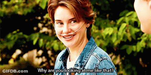 A Woman Wearing An Oxygen Mask Is Smiling While Talking To A Man . GIF
