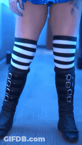 A Woman Wearing Black And White Striped Thigh High Socks GIF