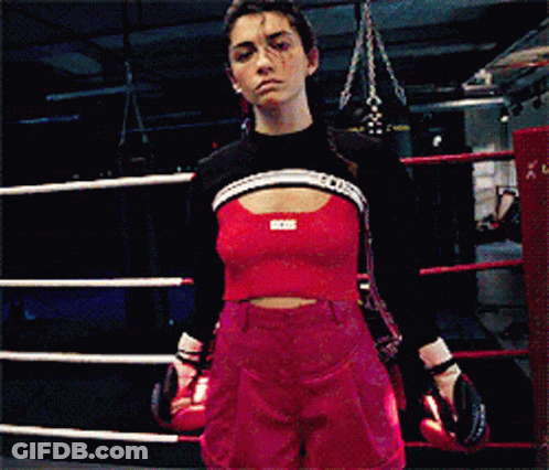 A Woman Wearing Boxing Gloves And A Crop Top That Says Bcci GIF