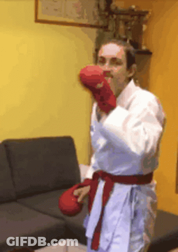 A Woman Wearing Boxing Gloves And A White Kimono GIF