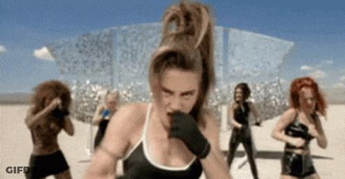 A Woman Wearing Boxing Gloves Is Standing In Front Of A Group Of Women GIF