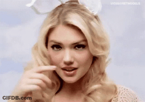 A Woman Wearing Bunny Ears Is Making A Funny Face With Her Finger . GIF