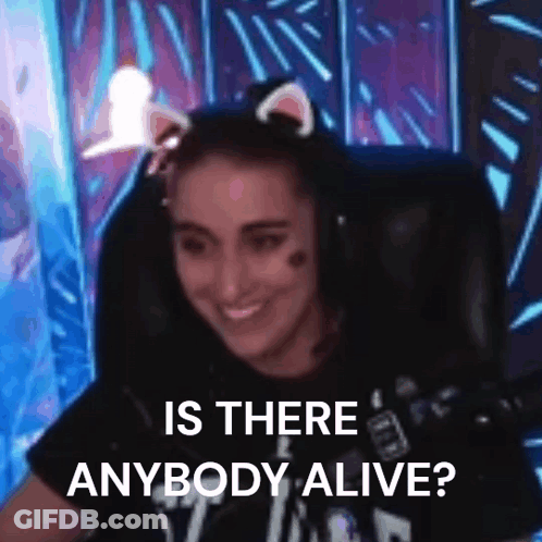 A Woman Wearing Cat Ears Is Sitting In A Chair With A Microphone And Smiling . GIF