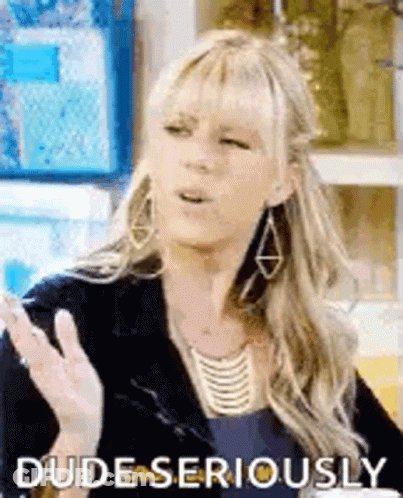 A Woman Wearing Earrings And A Necklace Is Making A Funny Face While Talking To Someone . GIF