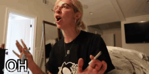 A Woman Wearing Glasses And A Black Shirt With The Word Oh On The Bottom Right GIF