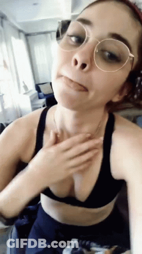 A Woman Wearing Glasses And A Bra Is Taking A Selfie GIF