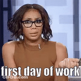 A Woman Wearing Glasses And A Brown Tank Top Is Sitting In Front Of A Window . GIF