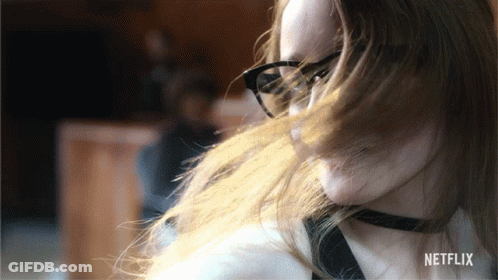 A Woman Wearing Glasses And A Choker Has A Netflix Logo In The Corner GIF