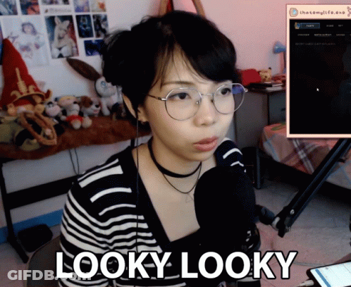 A Woman Wearing Glasses And A Choker Is Sitting In Front Of A Microphone And Says Looky Looky GIF