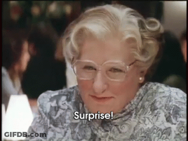 A Woman Wearing Glasses And A Floral Shirt Is Saying Surprise GIF