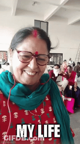 A Woman Wearing Glasses And A Green Scarf Is Smiling With The Words My Life Below Her GIF