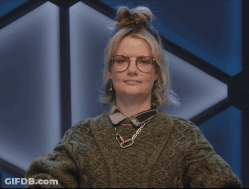 A Woman Wearing Glasses And A Green Sweater Making A Face GIF
