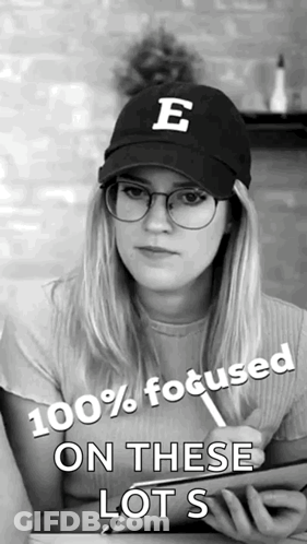 A Woman Wearing Glasses And A Hat With The Letter E On It Says 100 % Focused On These Lots GIF