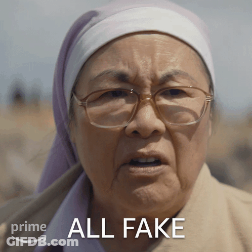 A Woman Wearing Glasses And A Head Scarf Has The Words All Fake Above Her GIF
