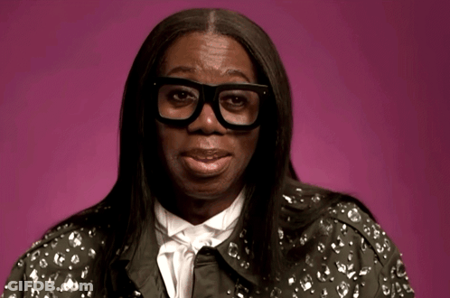 A Woman Wearing Glasses And A Jacket With A Floral Pattern GIF