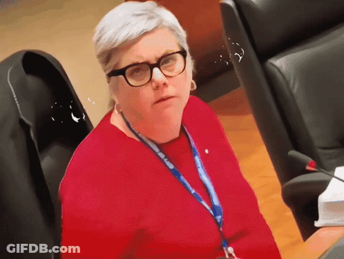 A Woman Wearing Glasses And A Lanyard That Says ' European Union ' GIF