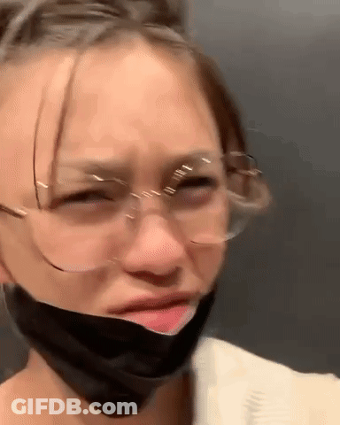 A Woman Wearing Glasses And A Mask On Her Face . GIF