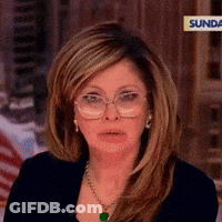 A Woman Wearing Glasses And A Necklace Is Sitting On A Sunday Show GIF