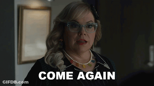 A Woman Wearing Glasses And A Pearl Necklace Is Saying Come Again GIF