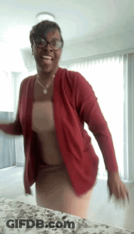 A Woman Wearing Glasses And A Red Cardigan Dancing GIF