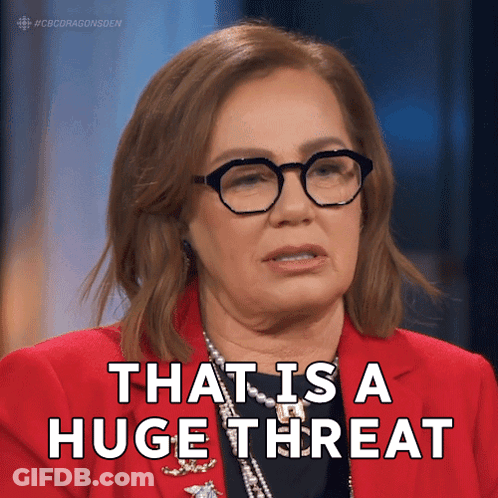 A Woman Wearing Glasses And A Red Jacket Says " That Is A Huge Threat " GIF
