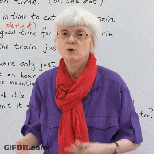 A Woman Wearing Glasses And A Red Scarf Stands In Front Of A White Board That Says " In Time To Cat " GIF