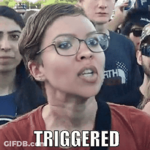 A Woman Wearing Glasses And A Red Shirt Is Making A Funny Face While Standing In Front Of A Crowd . GIF