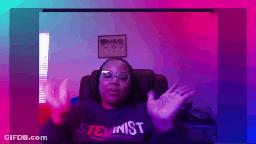 A Woman Wearing Glasses And A Shirt That Says Steminist GIF
