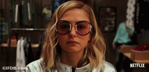 A Woman Wearing Glasses And A Silver Jacket With Netflix Written On The Bottom Right GIF