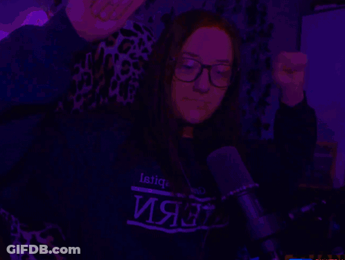 A Woman Wearing Glasses And A Sweater That Says ' Latic ' On It GIF