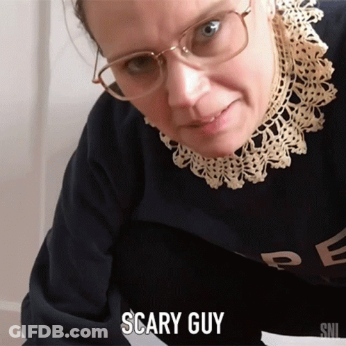 A Woman Wearing Glasses And A Sweater With The Word Scary Guy On It GIF