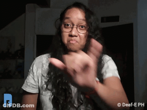 A Woman Wearing Glasses And A White Shirt Is Making A Funny Face GIF