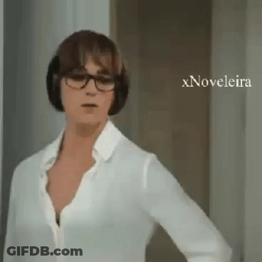 A Woman Wearing Glasses And A White Shirt Is Standing In Front Of A Door With Xnovelaira Written On The Bottom GIF