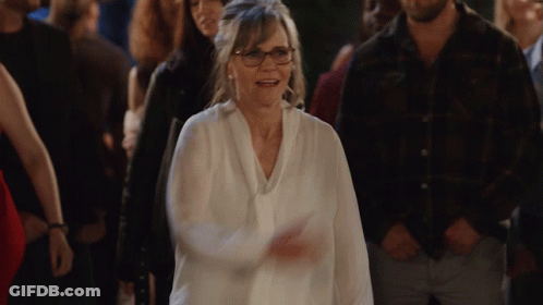 Woman With Glasses Walking Through Crowd GIF