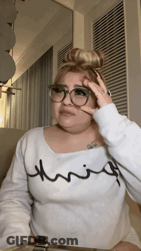 A Woman Wearing Glasses And A White Shirt That Says Thrifty On It GIF
