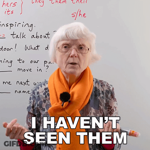 A Woman Wearing Glasses And An Orange Scarf Is Standing In Front Of A White Board And Says I Haven 'T Seen Them GIF