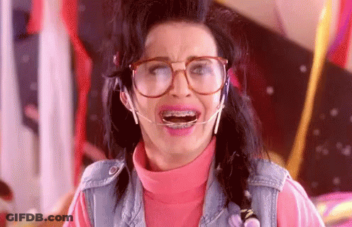 A Woman Wearing Glasses And Braces Is Making A Face . GIF