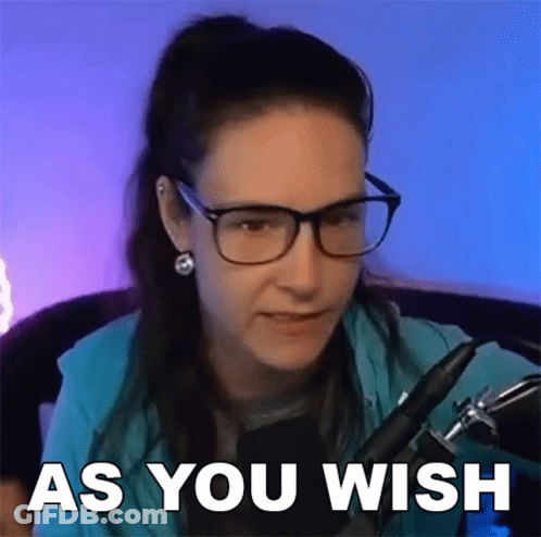 A Woman Wearing Glasses And Earrings Is Sitting In Front Of A Microphone With The Words As You Wish Above Her . GIF
