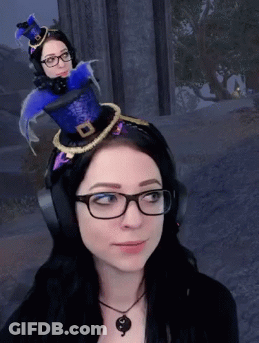 A Woman Wearing Glasses And Headphones Has A Blue Hat On Her Head GIF
