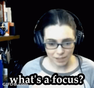 A Woman Wearing Glasses And Headphones Is Asking What 'S A Focus GIF