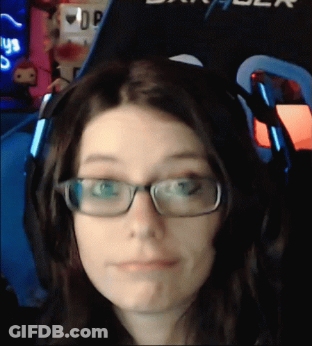 A Woman Wearing Glasses And Headphones Is Making A Face In Front Of A Sign That Says Dxracer GIF