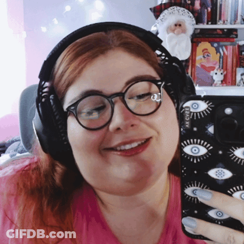 A Woman Wearing Glasses And Headphones Is Taking A Selfie With Her Phone GIF