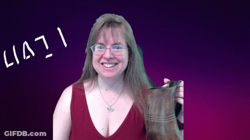 A Woman Wearing Glasses Holds A Brown Boot In Front Of A Purple Background That Says Lia71 GIF