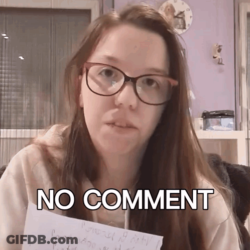A Woman Wearing Glasses Holds A Piece Of Paper That Says " No Comment " GIF